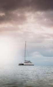White Sailboat on Sea Under Dark Clouds - Monaco Yacht Rentals