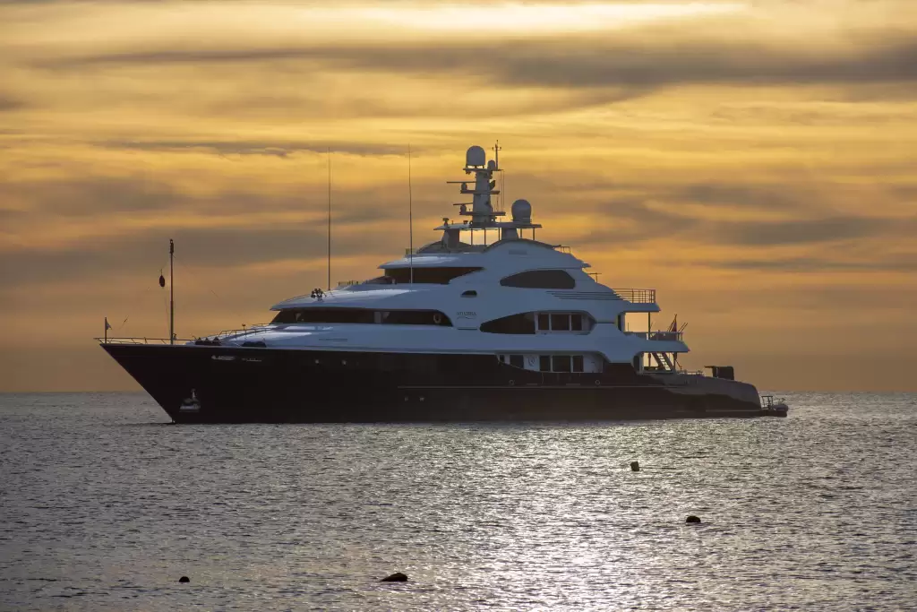 Luxury superyacht cruising at sunset near Monaco, representing key choices such as yacht size, amenities, crew, itinerary and charter style.